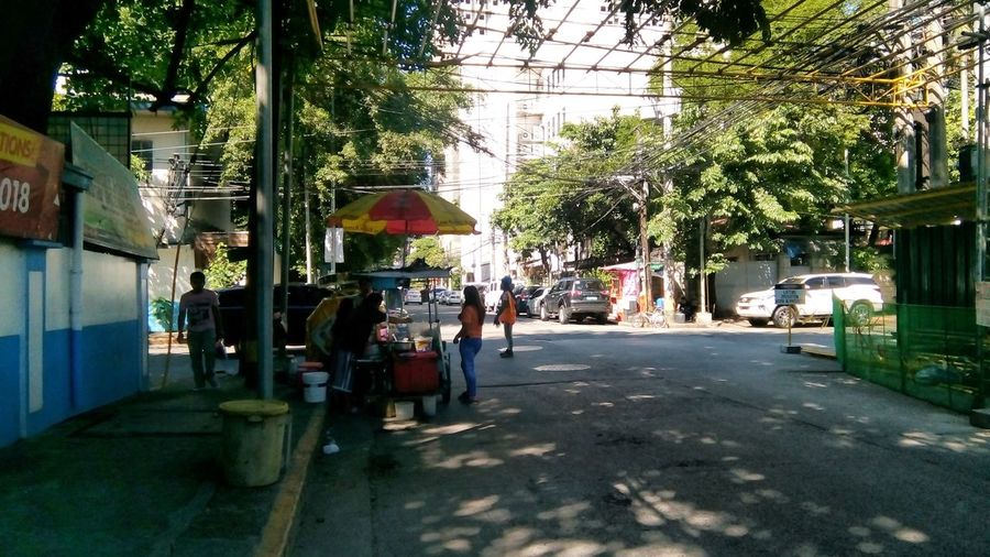 People walking on sidewalk by street in city