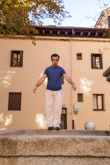Portrait of man standing against house
