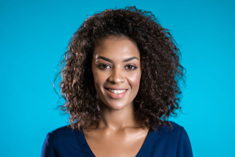 Portrait of smiling woman against blue background