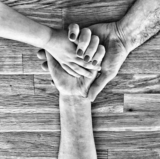 Cropped image of family with holding hands on table