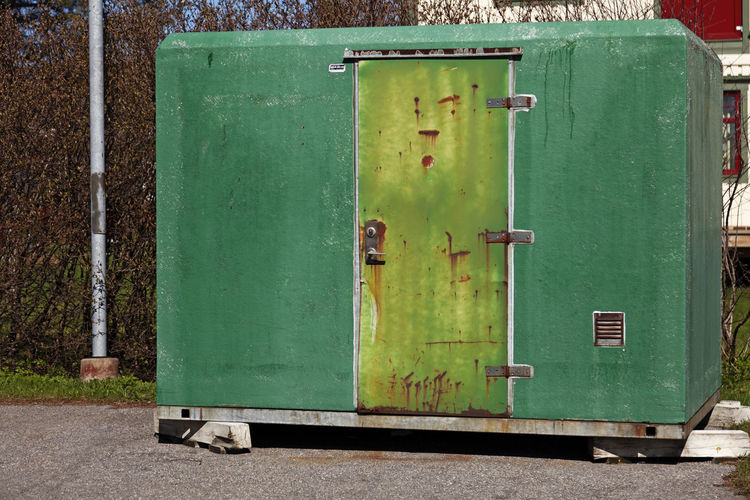 A green temporary toilet in the parking lot