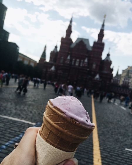 Cropped hand of woman holding ice cream cone in city