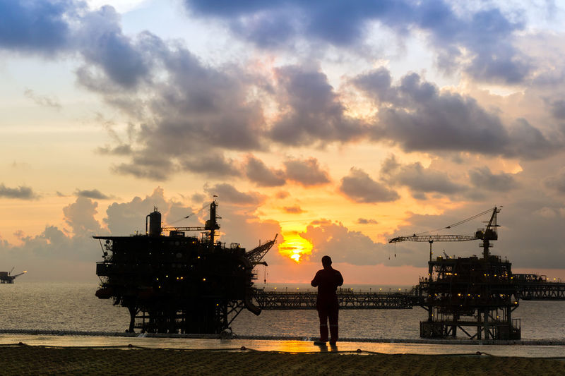 Silhouette of an offshore worker standing on a helipad of a construction work barge at offshore 