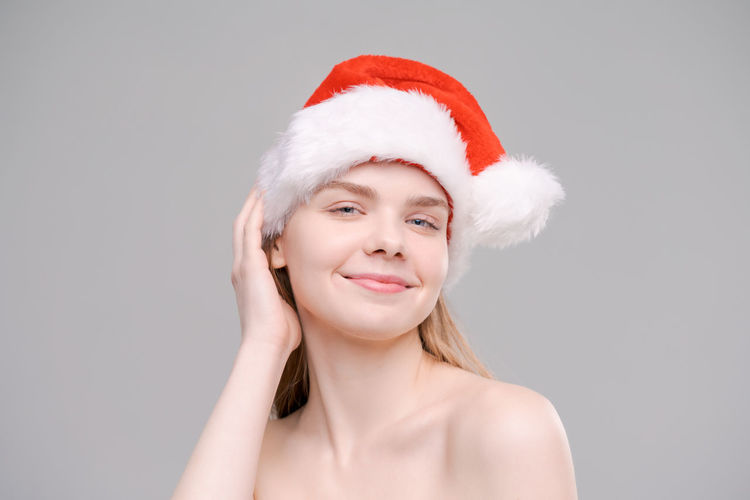 Portrait of young woman wearing santa hat against white background