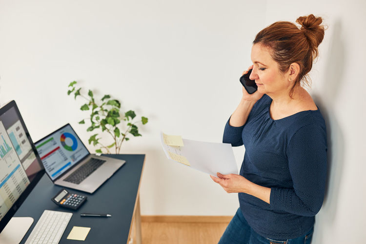 Woman entrepreneur having business conversation on phone. businesswoman working at desk in office