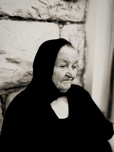 Close-up of sad senior woman wearing burka against wall