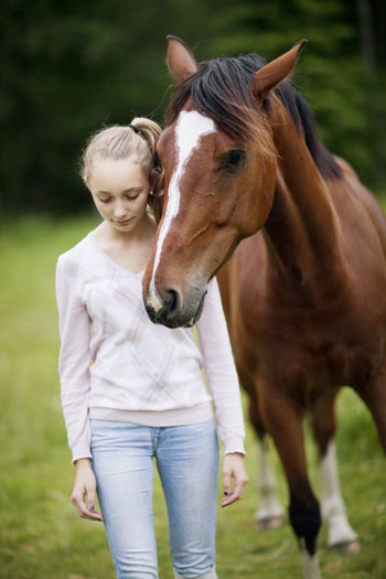 Girl with horse on meadow