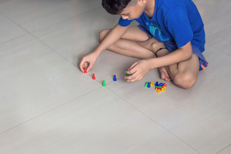 High angle view of boy playing with toy on floor at home