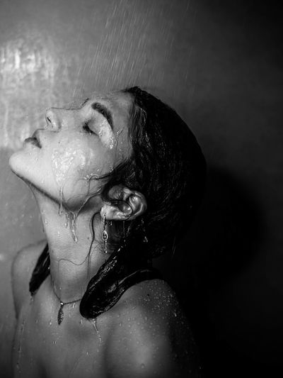 Close-up of woman taking shower in bathroom