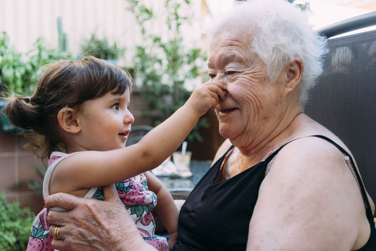 Grandmother and baby girl playing together on the terrace