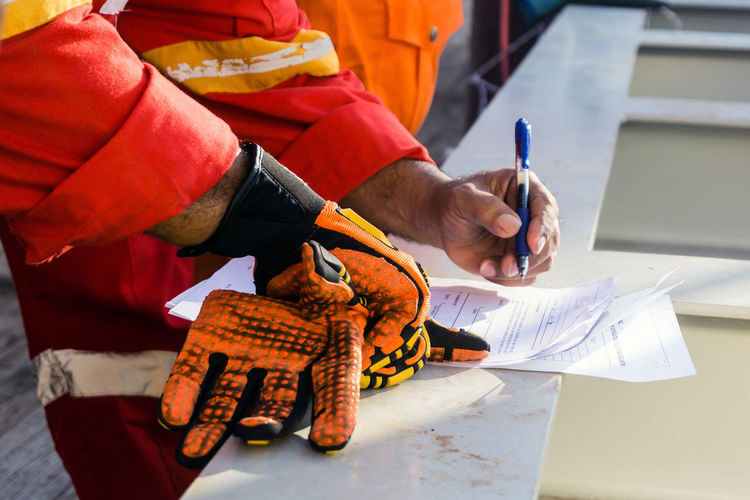 Offshore foreman review and put a signature to a safety checklist on a construction work barge