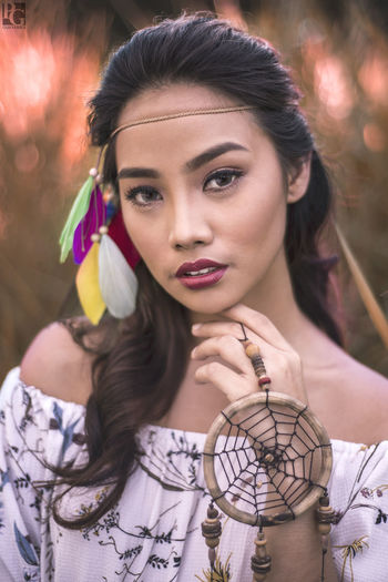 Close-up portrait of young woman with dreamcatcher