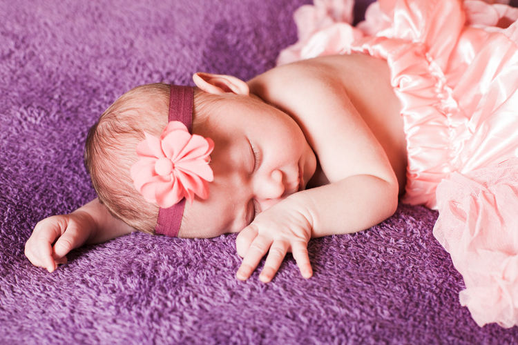 Cute baby sleeping on carpet at home