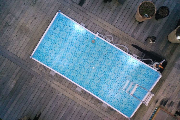 High angle view of tiled floor by swimming pool