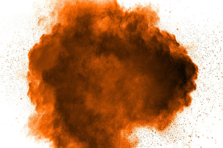 Defocused image of orange powder paint against white background