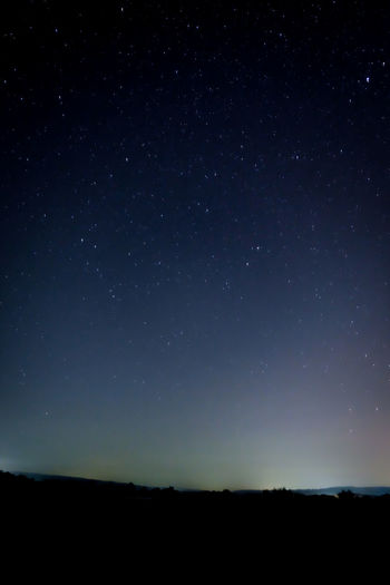 Scenic view of silhouette landscape against star field at night