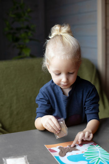 Portrait of cute boy drawing on table