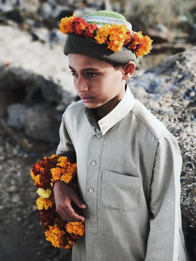 Boy wearing flowers while standing outdoors