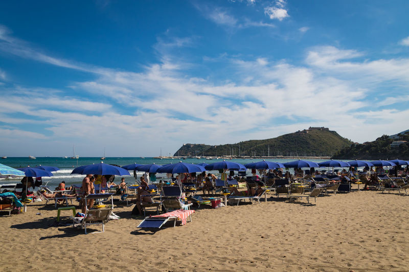 Group of people on beach against sky
