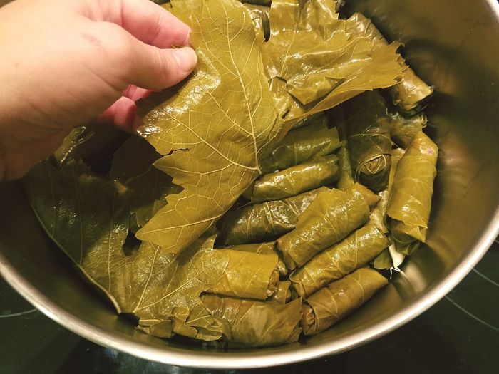 Cropped image of hand preparing dolmades