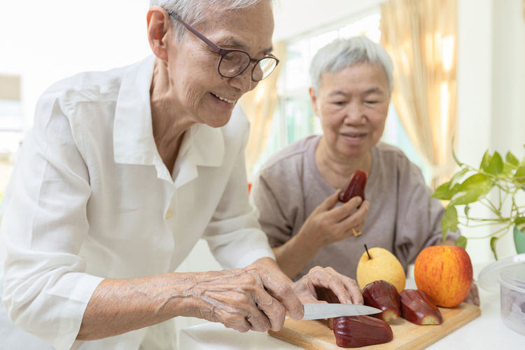 Portrait of senior man holding food at home