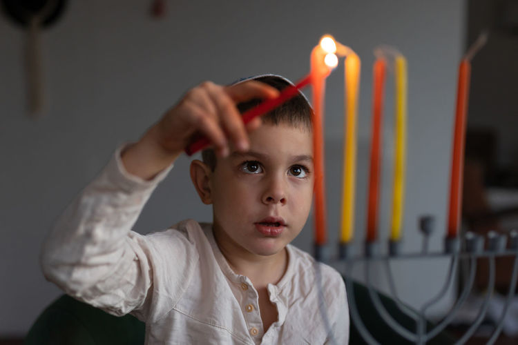 Portrait of young woman holding sparkler at home