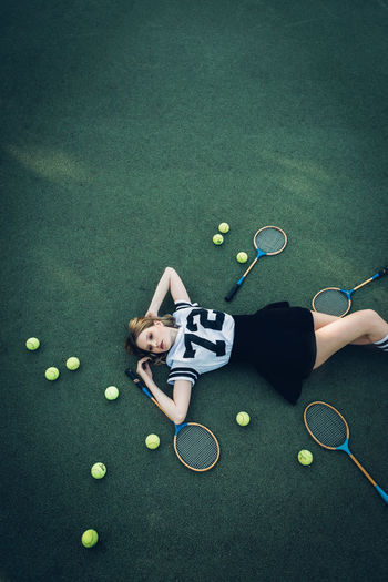 High angle view of tired young woman lying on court