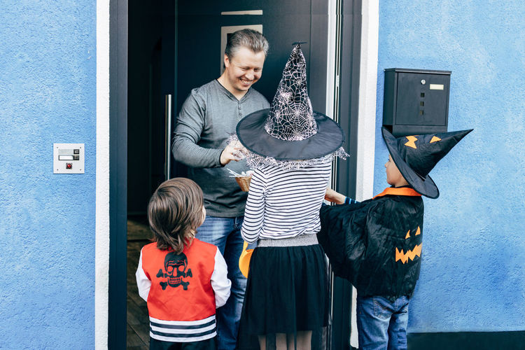 Halloween. children dressed as witch, pumpkin and pirate receive sweets 