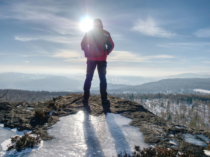 Hiker relaxing on top of hill and enjoying on sunny day. tourist trekking along a hill