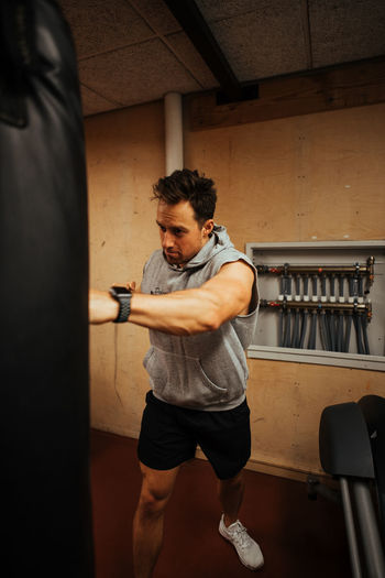 Man punching bag while exercising in gym