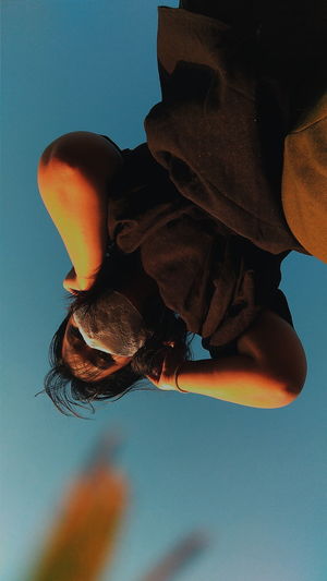 Low angle view of man against clear blue sky
