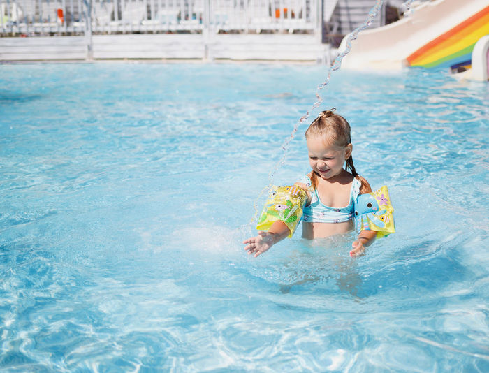 Full length of smiling girl in swimming pool