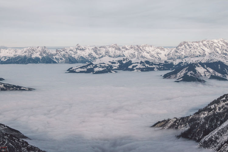 Scenic view of snowcapped mountains amidst clouds