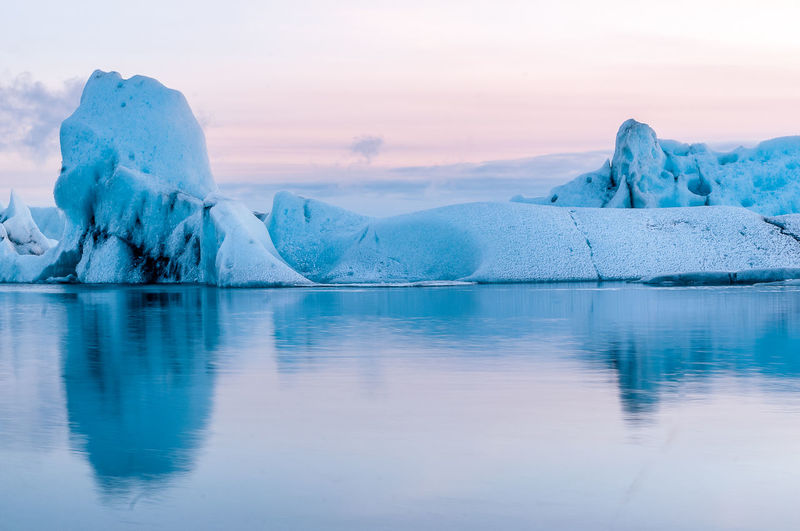 Scenic view of frozen lake against sky during sunset
