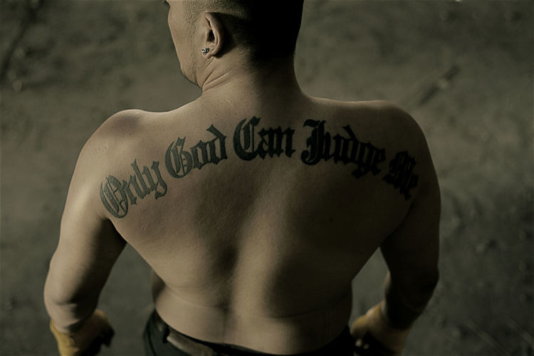 Rear view of shirtless man with tattoo text