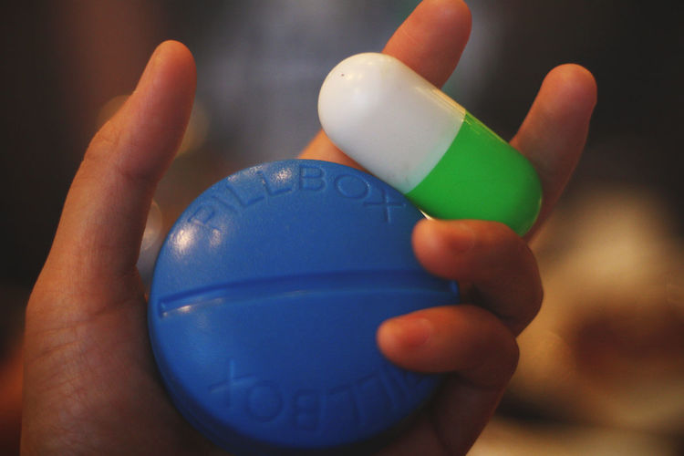 Close-up of hand holding pill container
