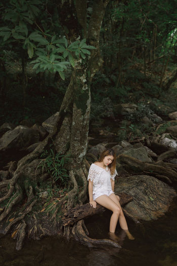 Alone beautiful young asian woman travel to visit waterfall forest in vacation trip. 