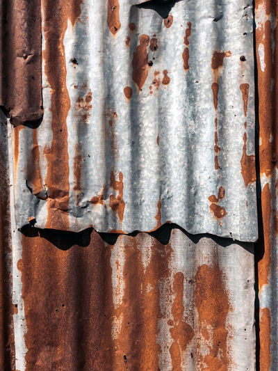 Old and rusty zinc sheet wall. vintage style metal sheet roof texture. pattern of old metal sheet. 