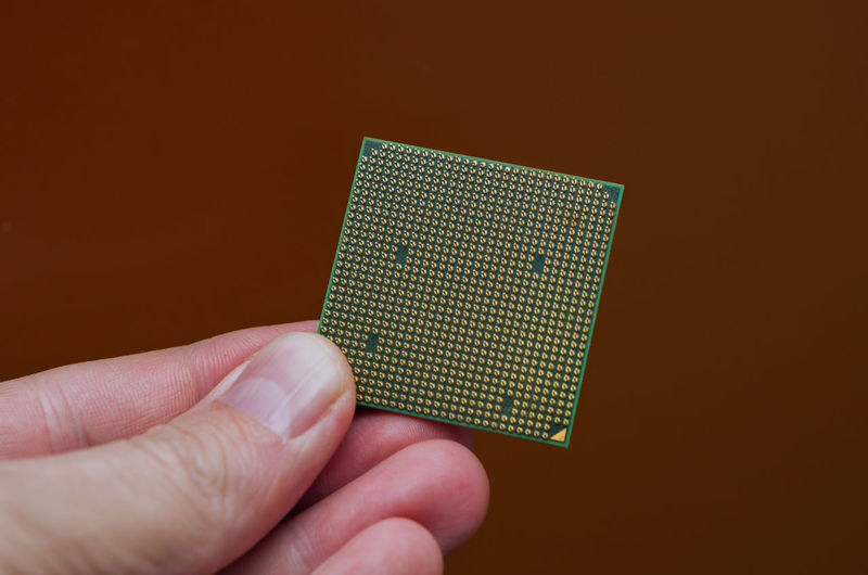 Computer processor in hand on orange background