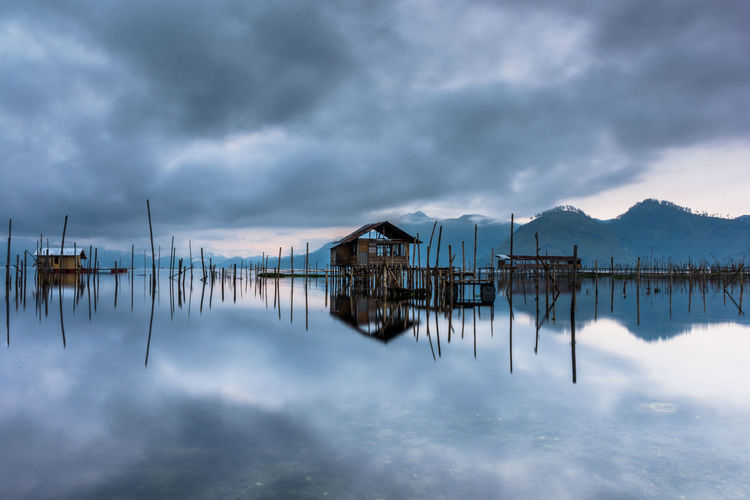 Panoramic view of wooden posts in lake against sky