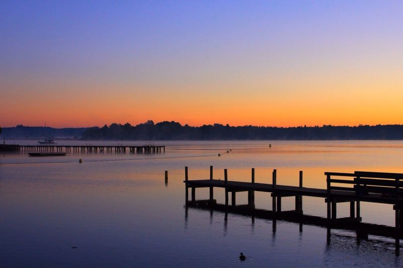 Pier on lake at sunset