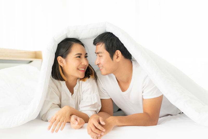 Young couple sitting on bed