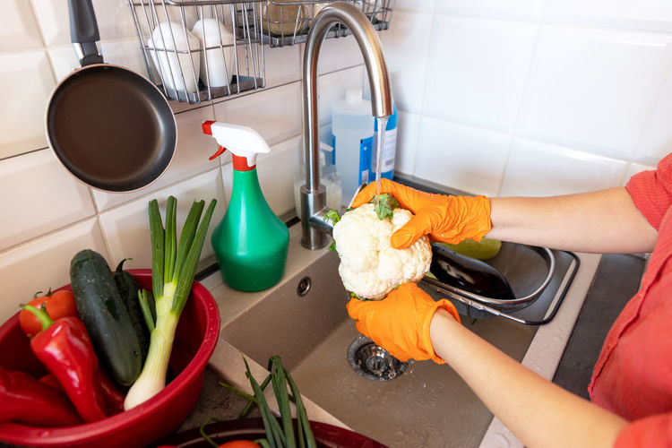 Washing vegetables in the kitchen under cold running tap water