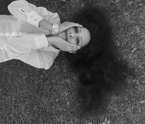 High angle portrait of young woman lying on grass