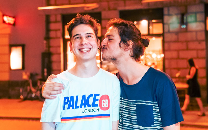 Gay man kissing boyfriend in city at night
