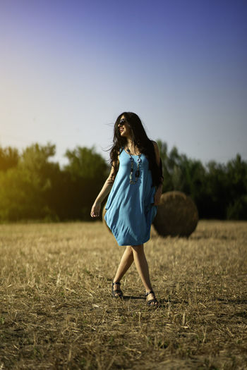 Full length of woman standing on field against clear sky