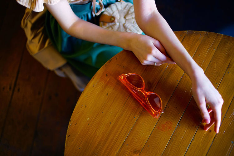 High angle view of woman sitting by wooden table