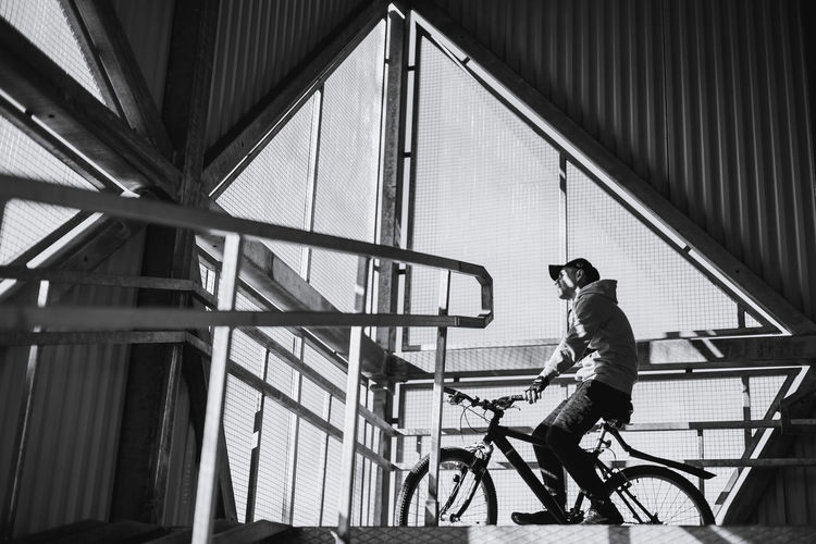 Low angle view of man with bicycle on bridge