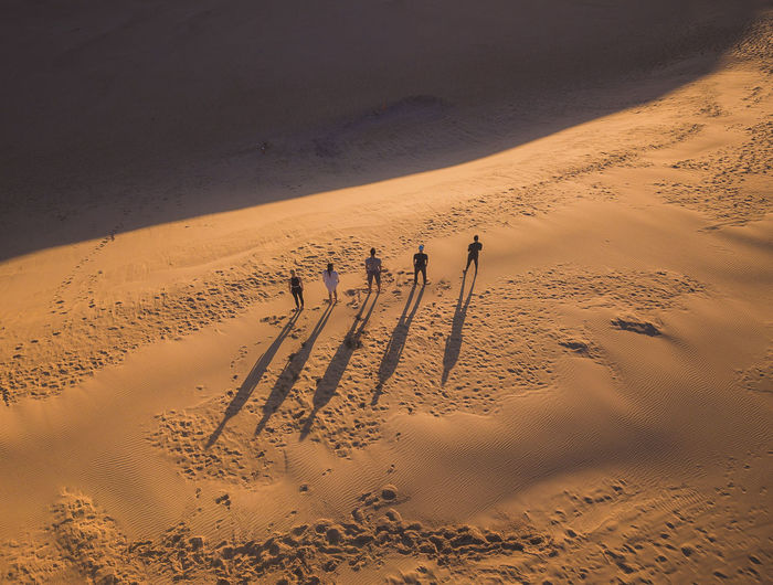 High angle view of people standing on sand dunes at desert