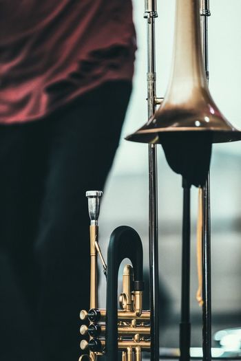 Midsection of person standing by trumpet